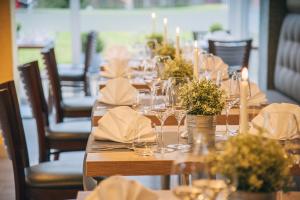 una mesa larga con copas de vino y flores. en Bernstein Acamed Resort en Nienburg