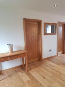 a room with a wooden table and a door at The Studio in Ingoldmells