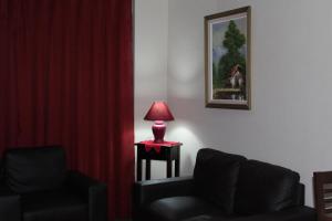 uma lâmpada vermelha sentada numa mesa ao lado de uma cadeira em Relax en La Serena em La Serena