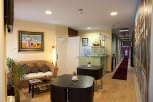 a living room with two tables and a couch at Pensión Jade in Castro-Urdiales