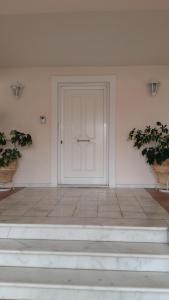 a white door in a white room with stairs at NN room near the Athens airport in Spata