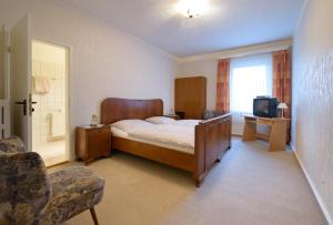 a bedroom with a bed and a television in it at Gasthof Runge in Barenburg