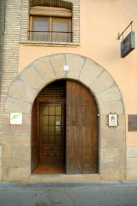 una gran puerta de madera en un edificio con arco en Casa Labata, en Adahuesca