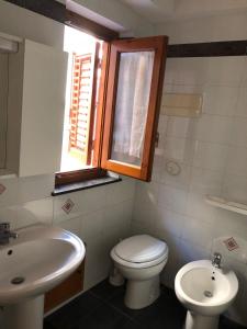 バゲリーアにあるBaarìa casa vacanzeのバスルーム(トイレ、洗面台付)、窓が備わります。
