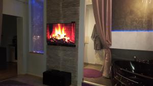 ペズナにあるLe Loveappartの暖炉付きのバスルーム(壁にテレビ付)