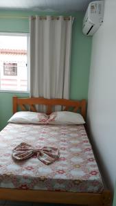 a bed with a pair of shoes sitting on it at Pousada Mar Verde in Florianópolis