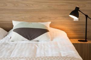 a bed with a black lamp and a pillow on it at Hotel Gullfoss in Haukadalur