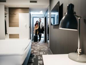 a man and a woman walking down a hallway at Q Hotel Kraków in Kraków