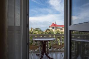 balcón con mesa y vistas al océano en Hotel Odeon, en Adler