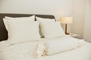 uma cama branca com almofadas brancas e um laço em MARIENSZTAT - SWAN2 em Varsóvia