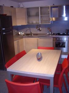 ランチャーノにあるCasa Lanciano Vecchiaのキッチン(木製テーブル、赤い椅子付)