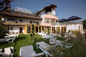 ein Hotel mit weißen Liegestühlen im Hof in der Unterkunft Hotel Am Hirschhorn - Wellness - Spa - and more in Wilgartswiesen