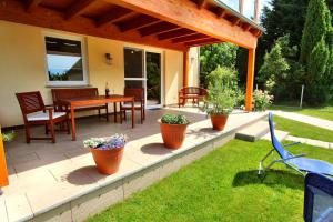 eine Terrasse mit einem Tisch, Stühlen und Pflanzen in der Unterkunft HAUS MÜRITZBRISE / EG-Fewo in Klink
