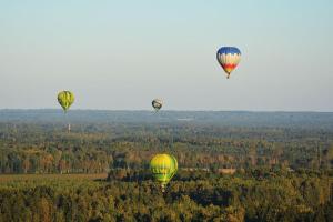three hot air balloons flying over a forest at Holiday House Aivari in Inčukalns