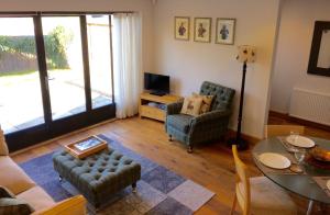 a living room with a table and chairs and a television at Hesmonds Oast Lodge in East Hoathly