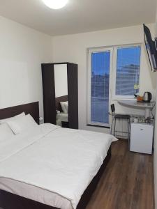 ein Schlafzimmer mit einem großen weißen Bett und einem Schreibtisch in der Unterkunft Rooftop Oscar Rooms in Sofia