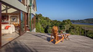 einen Balkon mit einem Bett und einem Stuhl auf einem Haus in der Unterkunft Westend House in Seafield