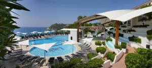 an overhead view of a swimming pool with chairs and umbrellas at Hotel Village Scoglio Della Galea in Capo Vaticano +40 photos