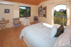 a bedroom with a large bed and a balcony at La Maisonette in Onetangi