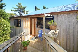 a wooden deck with a house with a bench on it at La Maisonette in Onetangi