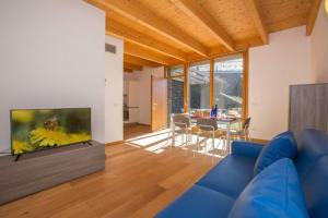 een woonkamer met een blauwe bank en een tv bij Paradiso del lago in Bellano