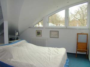 ヘリングスドルフにあるSeepark Heringsdorfのベッドルーム1室(白いベッド1台、窓2つ付)