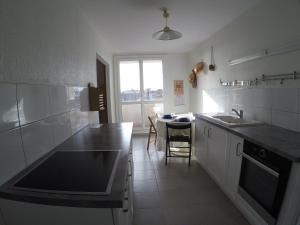 een witte keuken met een wastafel en een tafel bij Appartement 4p 70m2 plein centre avec parking in Agen