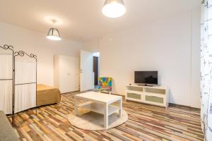 a room with a bed and a table and a tv at Urban Retreat Near Metro & Mega Mall in Bucharest