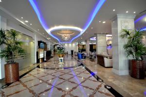 a lobby with a blue lighting and palm trees at Grandeur East in Al Khobar