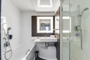 a bathroom with a sink and a toilet and a shower at Novotel Suites Paris Montreuil Vincennes in Paris