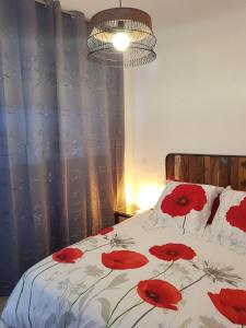 a bedroom with a bed with red flowers on it at Gite les Coquelicots in Lédenon