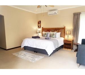 a bedroom with a large bed and a blue chair at Oudtshoorn Guest House in Oudtshoorn