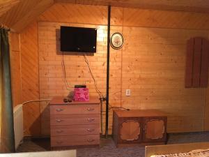 a room with a dresser and a tv on a wall at ГОСТИННИЙ ДІМ ЛЕЛИЧ in Vorokhta