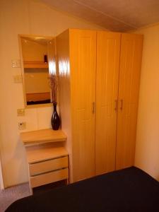 a bedroom with a cabinet and a dresser and a mirror at Newquay View Hideaway in Newquay