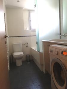 a bathroom with a toilet and a washing machine at Elvita Athens Sea View Maisonette in Athens