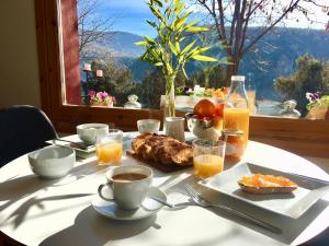 - Mesa con desayuno de café y zumo de naranja en Can Lamat, en Talarn