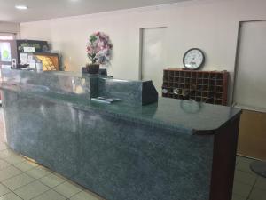 a lobby with a counter with a clock on the wall at Budget Inn Motel in Austin