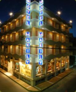um edifício com luzes azuis na lateral em Hotel Marily em Pírgos