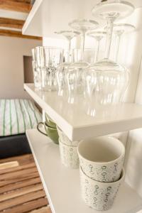 a row of wine glasses sitting on a shelf at Fewo " Schmiede " Innenstadt, ruhige Lage, große Terrasse, Wlan inkl. in Rüdesheim am Rhein