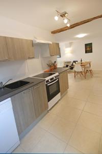 a large kitchen with a stove and a table at Cottage at 7 in Sainte-Foy-la-Grande