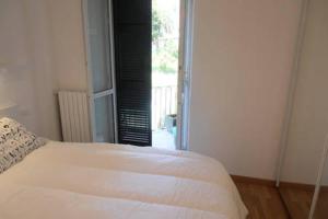 białe łóżko w pokoju z oknem w obiekcie Bilocale Santa Margherita Ligure w mieście Santa Margherita Ligure