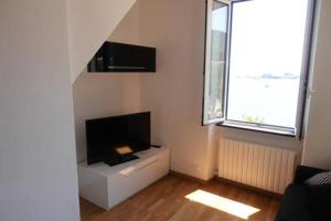 a living room with a flat screen tv and a window at Happy Haven al mare by Portofino in Santa Margherita Ligure