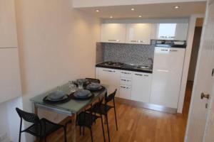 a kitchen with a table and chairs and a kitchen with white cabinets at Happy Haven al mare by Portofino in Santa Margherita Ligure