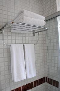 un grupo de toallas colgando de un estante en el baño en Brasília Santana Gold Flat, en São Paulo