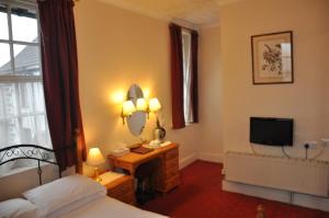 a hotel room with a bed and a television at The Roundabout Hotel in Fareham