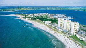 eine Luftansicht auf einen Strand mit Gebäuden und das Meer in der Unterkunft Ferienwohnung am Südstrand in Burgtiefe auf Fehmarn 