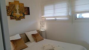 a bedroom with a white bed and a window at Appartement Le Chantilly in Cagnes-sur-Mer