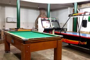 a room with a pool table and a video game at Hotel Chalé São Jorge in Aparecida