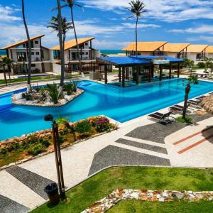 uma piscina com água azul num resort em Taiba Beach Resort Casa com piscina em Taíba