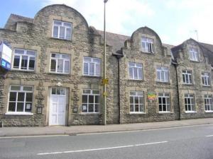 an old brick building on the side of a street at Luxury 2 bed Apartment in Witney